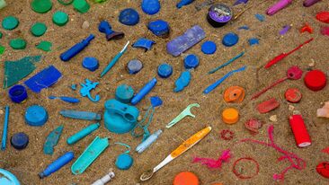 colourful plastic waste on beach sustainability