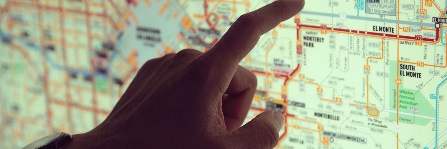 Finger pointing to a point on a rail route map