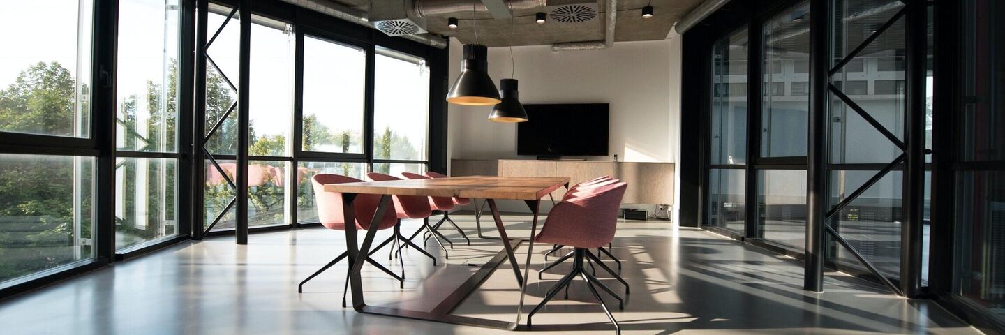 empty architectural office space with table and chair large windows