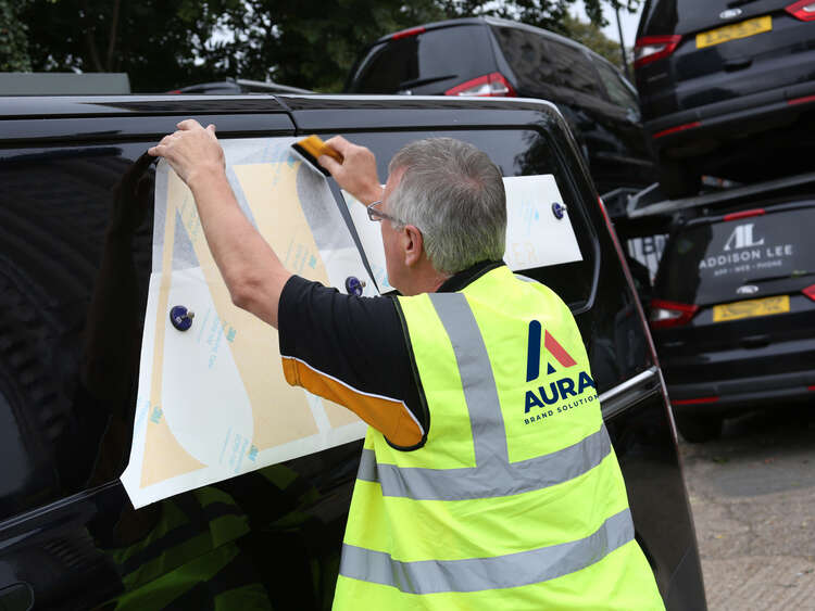 Aura Brand Solutions Fitter installing Addison Lee Graphics