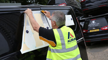 Aura Brand Solutions Fitter installing Addison Lee Graphics