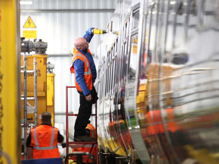 Aura installer applying wrap to train