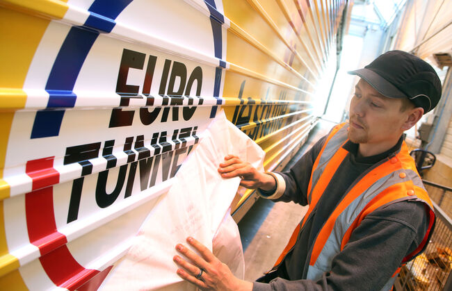 Man applying the euro tunnel logo onto the carriage exterior
