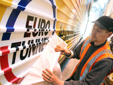 Man applying the euro tunnel logo onto the carriage exterior