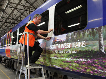 Installing promotional train wrap on South West Trains carriage