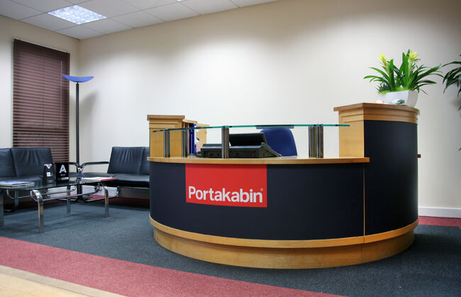 Portakabin reception desk with wrapped finish in brand colours with logo