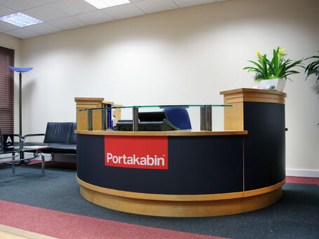 Portakabin reception desk with wrapped finish in brand colours with logo